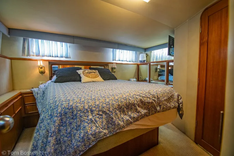 Slide: The Image of 1986 Chris-Craft Corinthian bedroom with cozy bed, floral bedding, and wooden accents. - 21