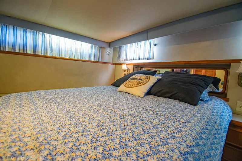 Slide: The Image of 1986 Chris-Craft Corinthian cabin interior with cozy bed and decorative pillows. - 22