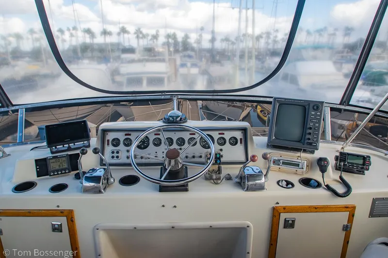 Slide: The Image of 1986 Chris-Craft Corinthian boat helm with steering wheel, gauges, and navigation equipment. - 44