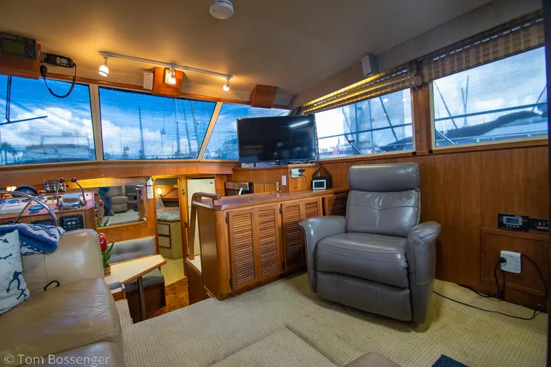 Slide: The Image of 1986 Chris-Craft Corinthian yacht interior with leather seating, TV, and wood paneling. - 8