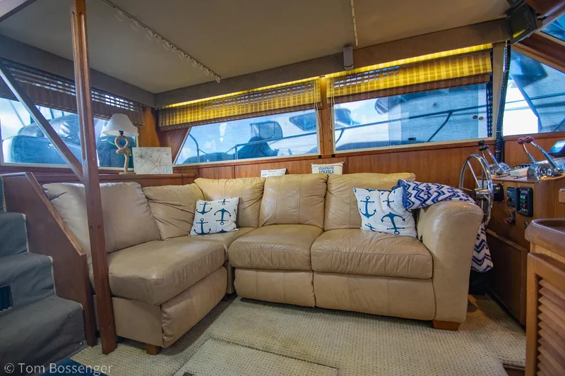 Slide: The Image of Interior of 1986 Chris-Craft Corinthian yacht with beige leather sofa and nautical decor. - 9