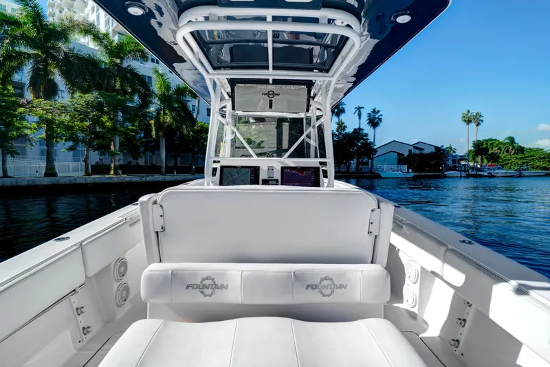Slide: The Image of 2016 Fountain 38 CC Tournament Edition boat interior with white seating and waterfront view. - 17