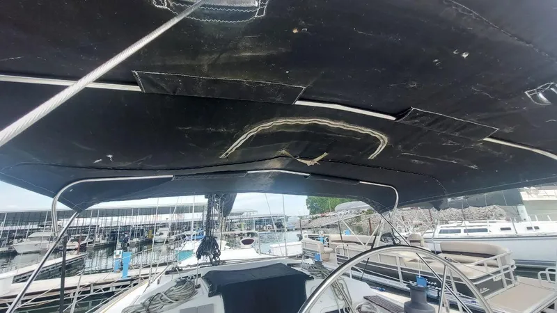Slide: The Image of 1987 Hunter 34 sailboat cockpit with black canopy, docked at marina. - 10