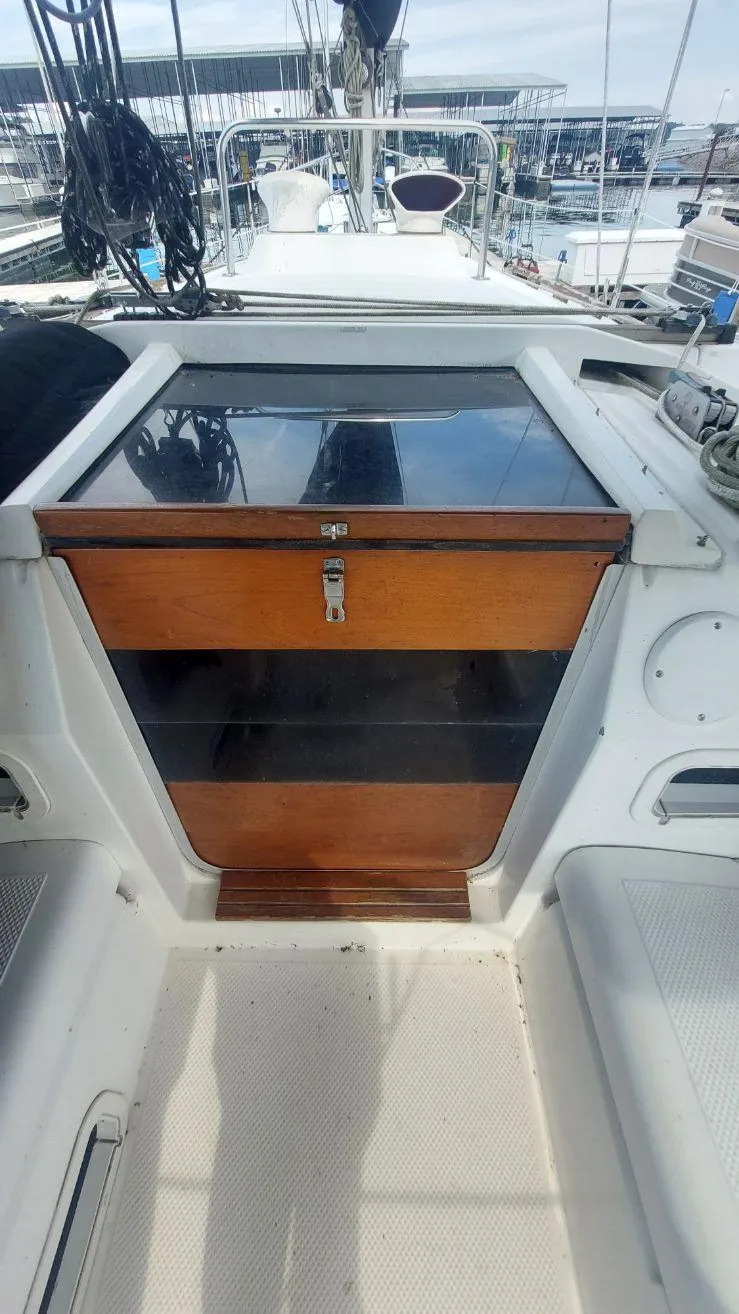 Slide: The Image of 1987 Hunter 34 sailboat cockpit with wooden hatch and marina view. - 14