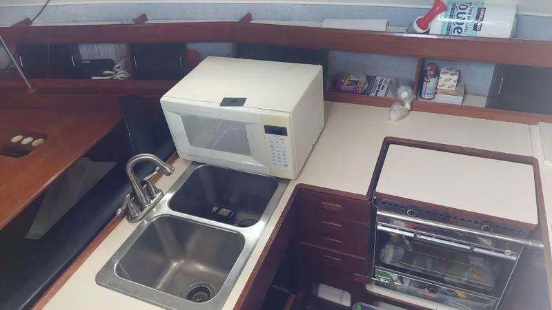 Slide: The Image of 1987 Hunter 34 yacht kitchen with microwave, dual sink, and stove. - 16