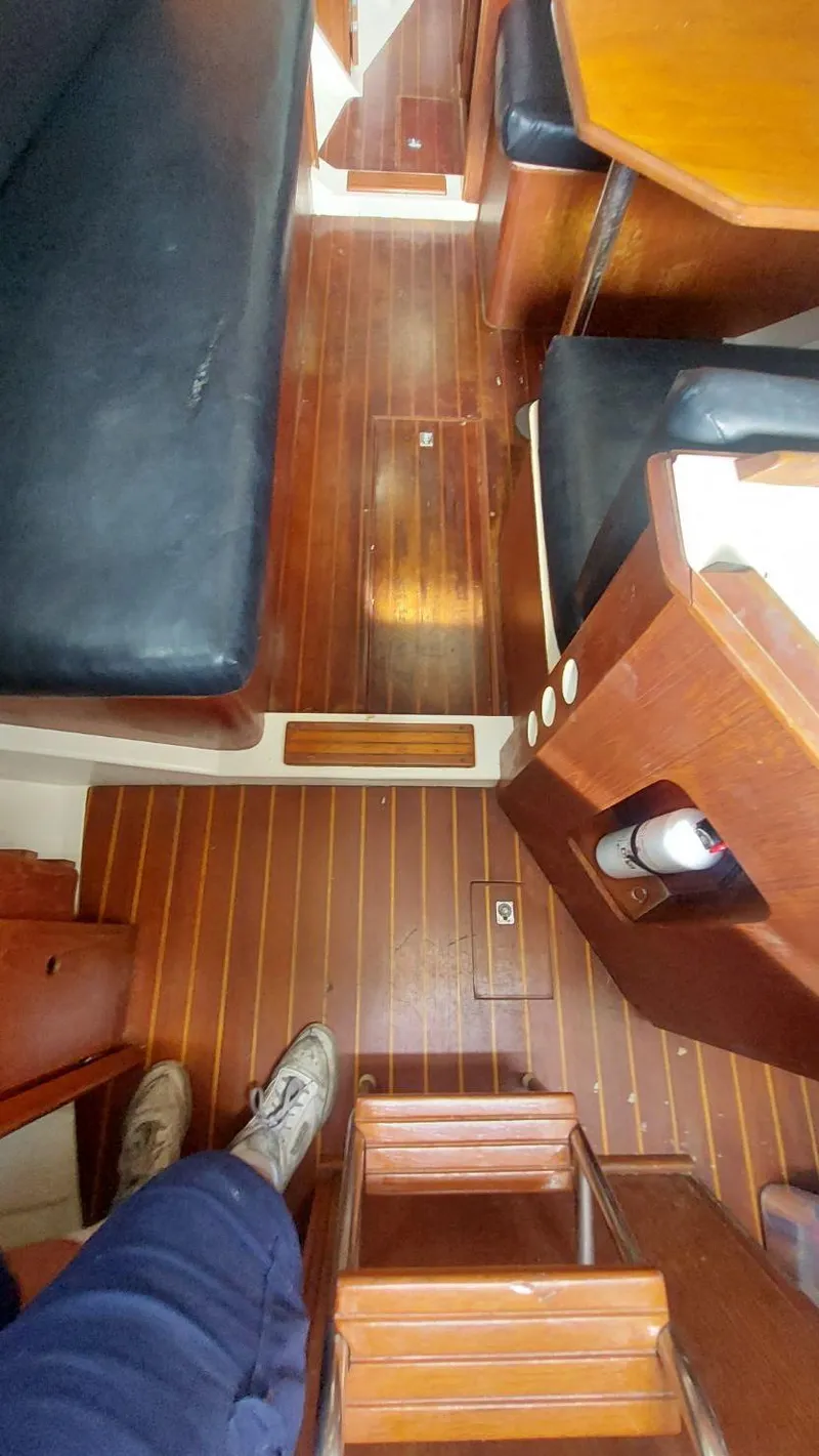 Slide: The Image of Interior of 1987 Hunter 34 sailboat with wooden flooring and seating area. - 21