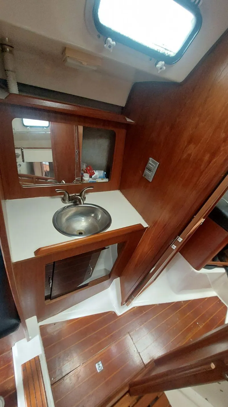Slide: The Image of 1987 Hunter 34 yacht interior with wooden cabinetry and stainless steel sink. - 25