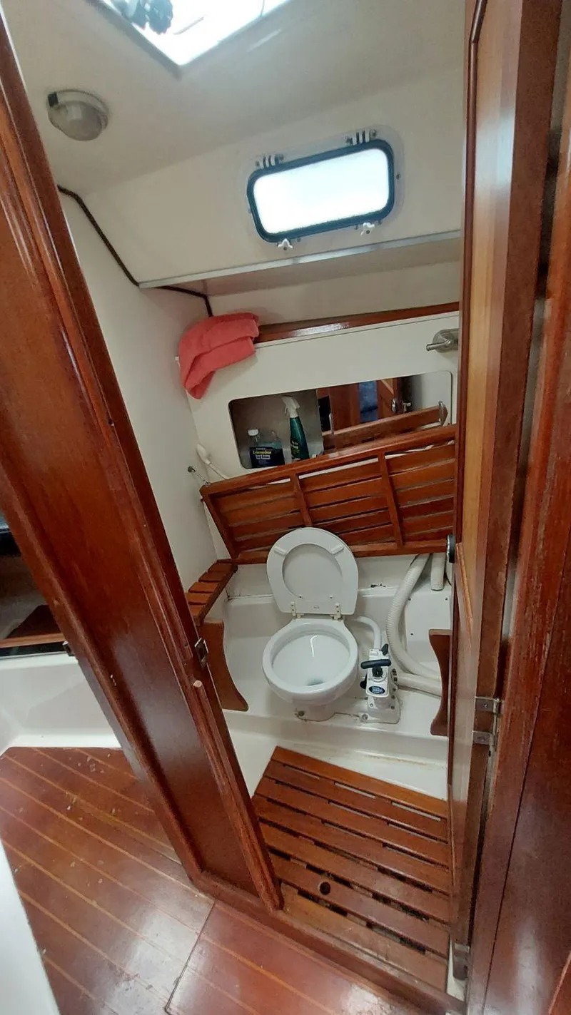 Slide: The Image of 1987 Hunter 34 sailboat bathroom with wooden cabinetry and compact design. - 26