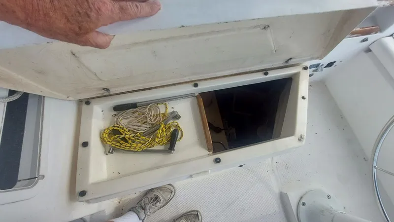 Slide: The Image of Open storage compartment on 1987 Hunter 34 sailboat deck with ropes and tools. - 36