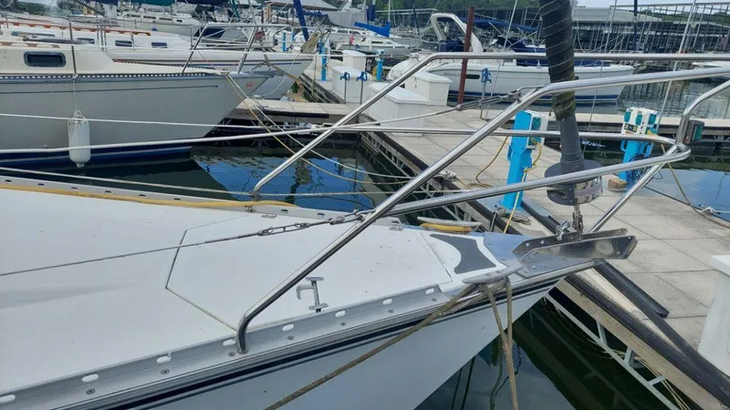 Slide: The Image of 1987 Hunter 34 sailboat docked at marina, featuring sleek bow and stainless steel railings. - 40