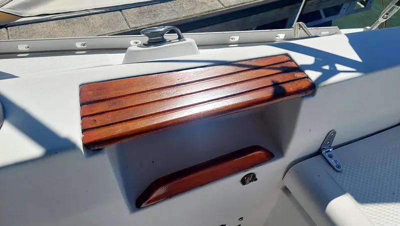 Slide: The Image of 1987 Hunter 34 sailboat cockpit with wooden trim and white fiberglass surface. - 44