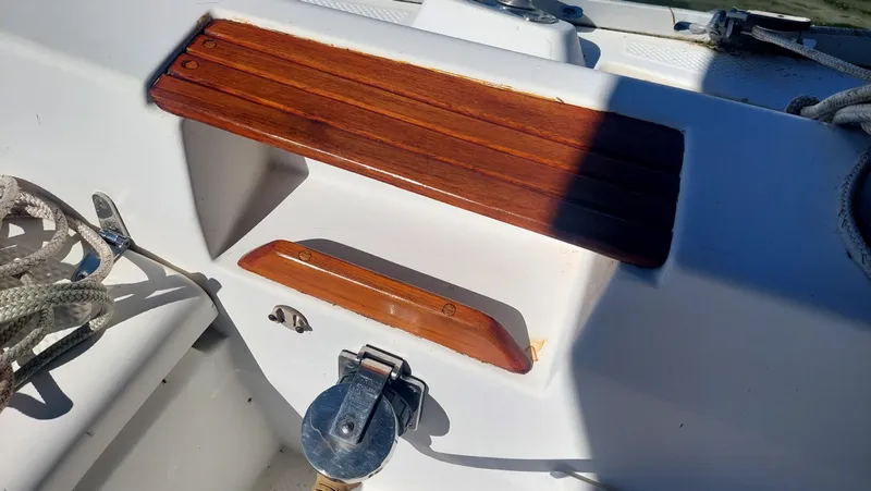 Slide: The Image of 1987 Hunter 34 sailboat deck with wooden trim and metal fittings. - 45
