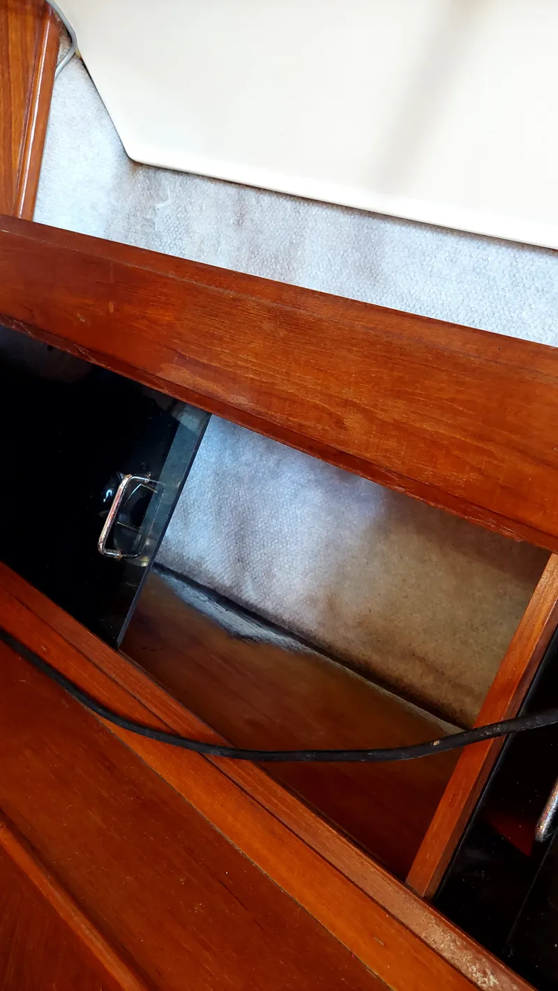 Slide: The Image of Interior view of a 1987 Hunter 34 sailboat, featuring wooden cabinetry and storage space. - 47