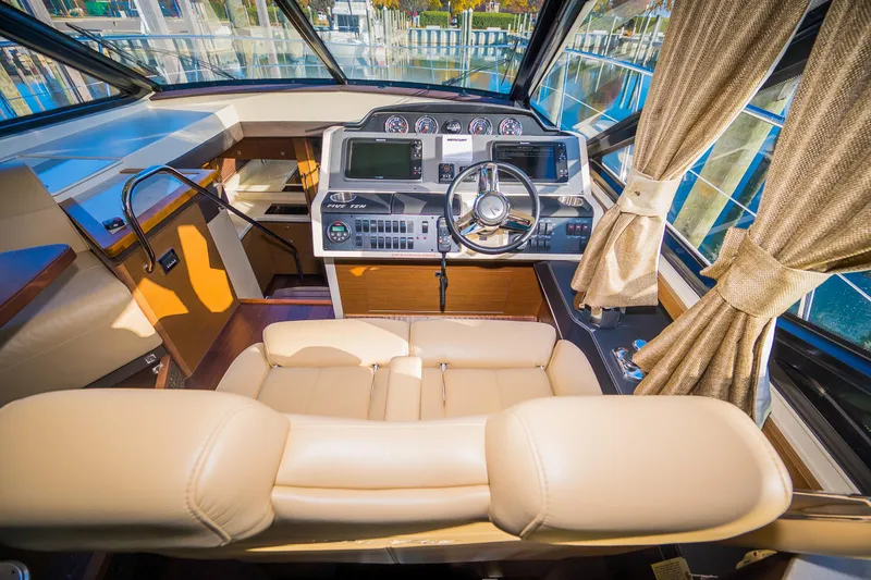 Slide: The Image of 2015 Sea Ray Sundancer 510 helm with leather seating and modern navigation controls. - 10