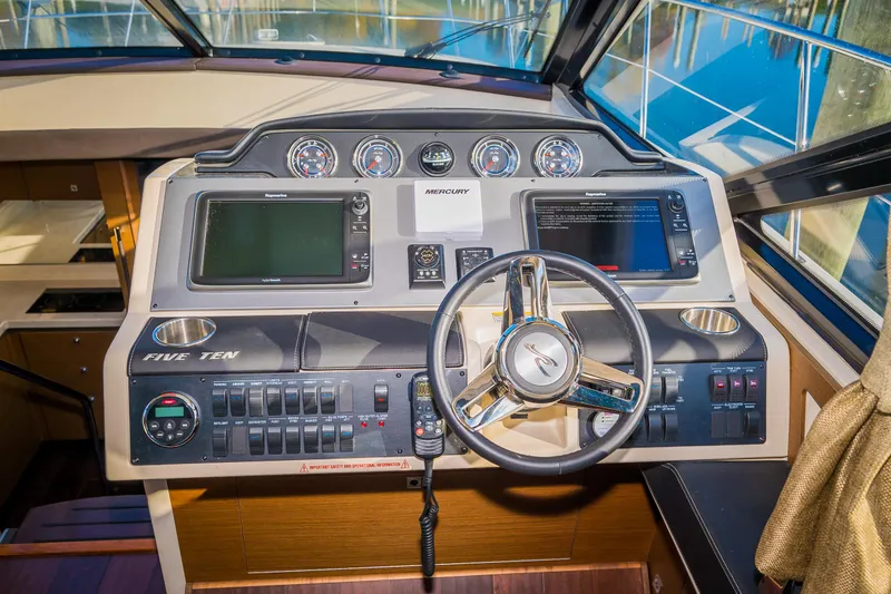 Slide: The Image of 2015 Sea Ray Sundancer 510 helm with advanced navigation controls and steering wheel. - 11