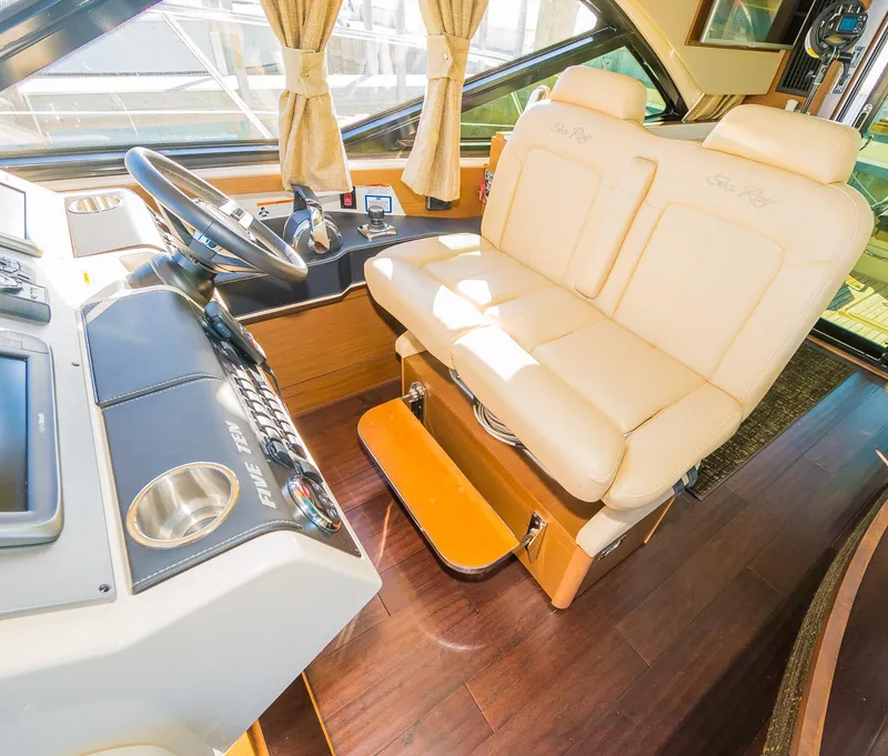 Slide: The Image of 2015 Sea Ray Sundancer 510 helm station with dual beige captain seats. - 22