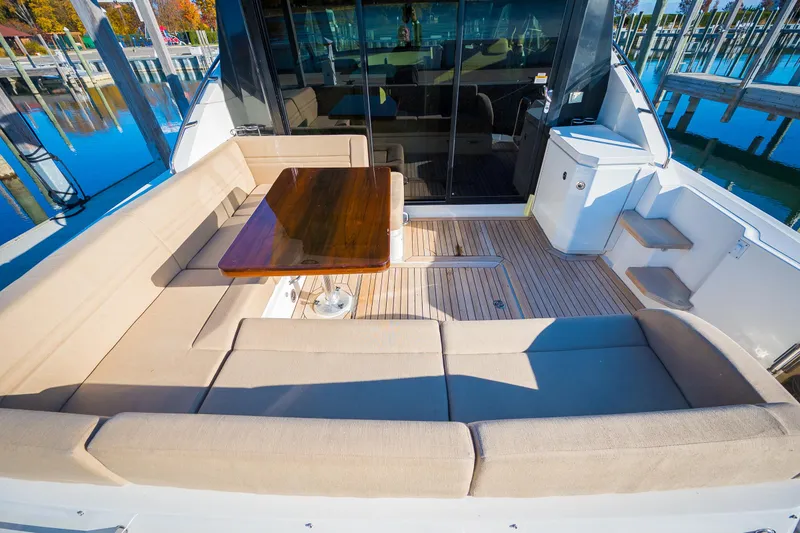 Slide: The Image of 2015 Sea Ray Sundancer 510 yacht with spacious outdoor seating and wooden table. - 3