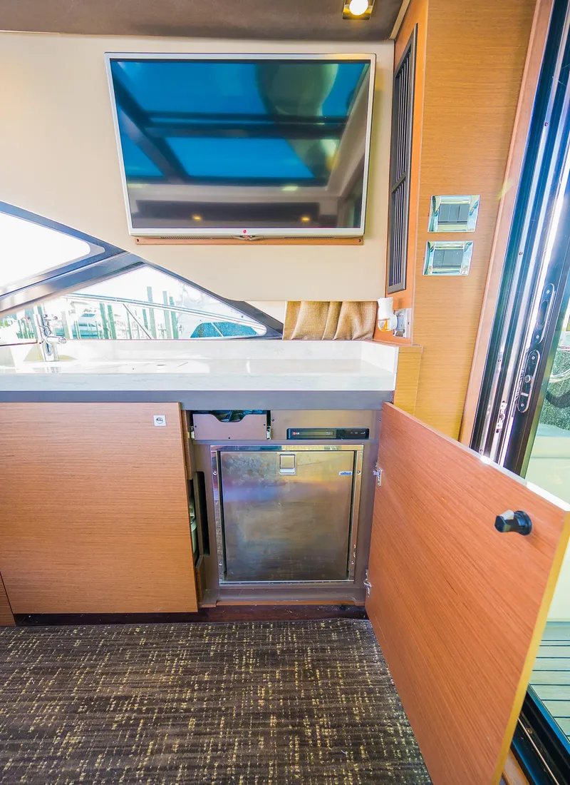Slide: The Image of 2015 Sea Ray Sundancer 510 interior kitchen area with TV and mini-fridge. - 33