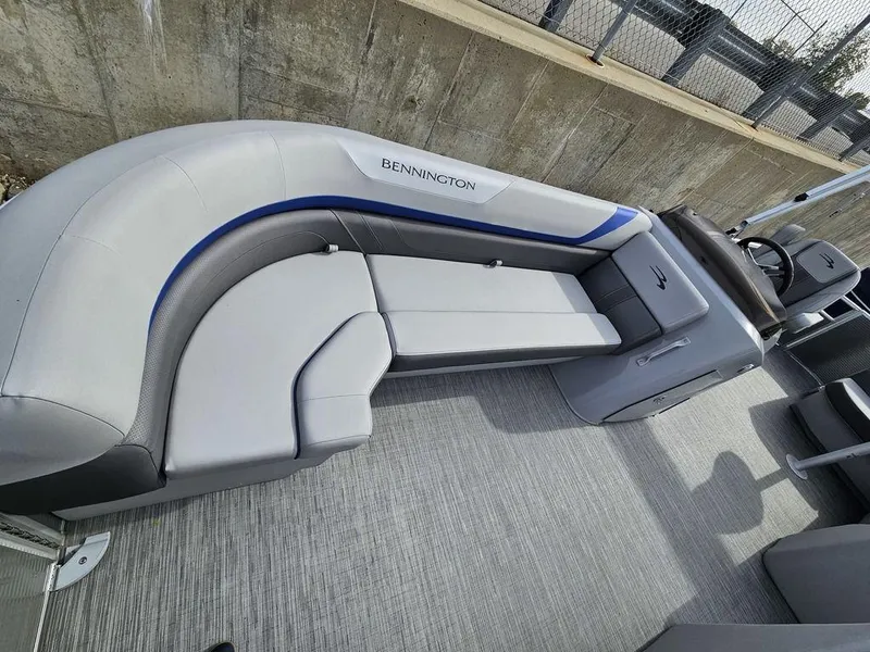 Slide: The Image of 2023 Bennington 21 SXL pontoon boat interior with gray seating and steering console. - 4