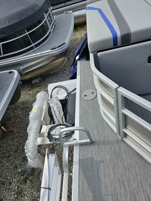 Slide: The Image of 2023 Bennington 21 SXL pontoon boat, docked, showing deck and seating area. - 6