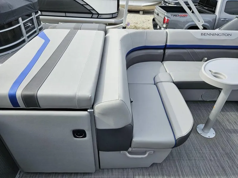 Slide: The Image of 2023 Bennington 21 SXL boat interior with gray and blue seating and table. - 7
