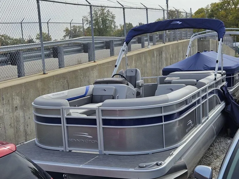 Slide: The Image of 2023 Bennington 21 SXL pontoon boat parked near a fence. - 8