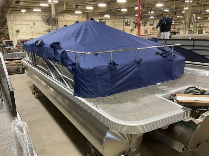 Slide: The Image of 2023 Bennington 22 LSB pontoon boat with blue cover in a warehouse. - 10