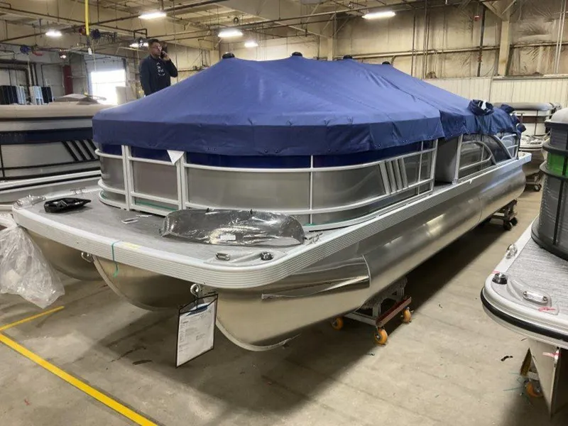 Slide: The Image of 2023 Bennington 22 LSB pontoon boat with blue cover in a warehouse. - 16