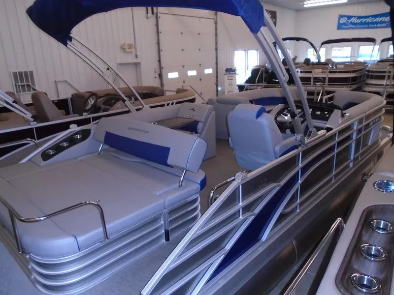 Slide: The Image of 2023 Bennington 22 LSB pontoon boat with blue and gray seating in showroom. - 24