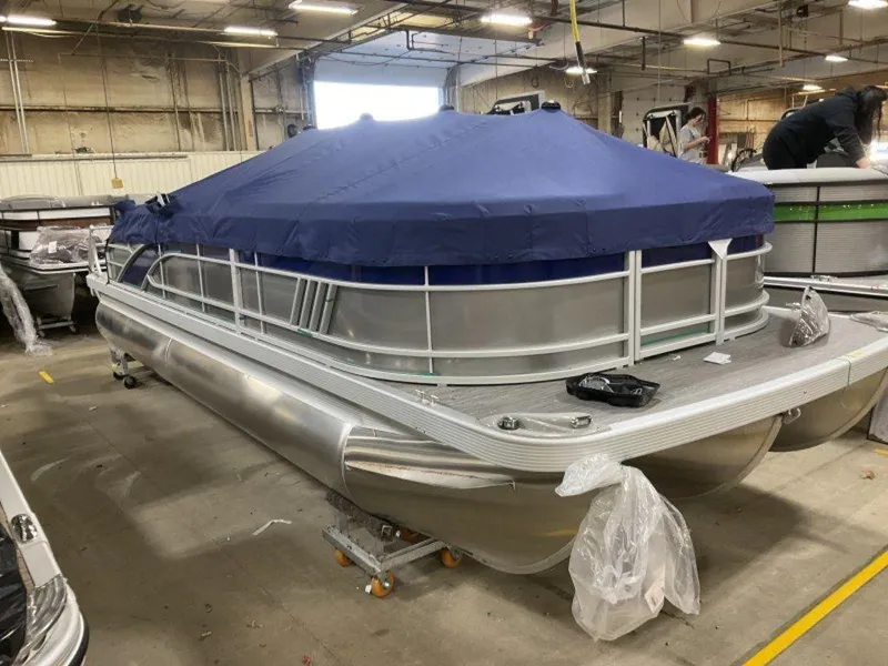 Slide: The Image of 2023 Bennington 22 LSB pontoon boat with blue cover in a warehouse. - 6