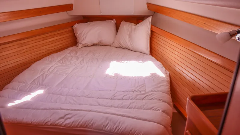 Slide: The Image of Cozy cabin interior of 2010 Catalina 375 sailboat with wooden paneling and comfortable bedding. - 15