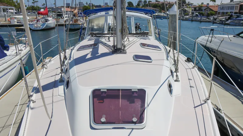 Slide: The Image of 2010 Catalina 375 sailboat docked in a marina, showcasing deck and hatch details. - 3