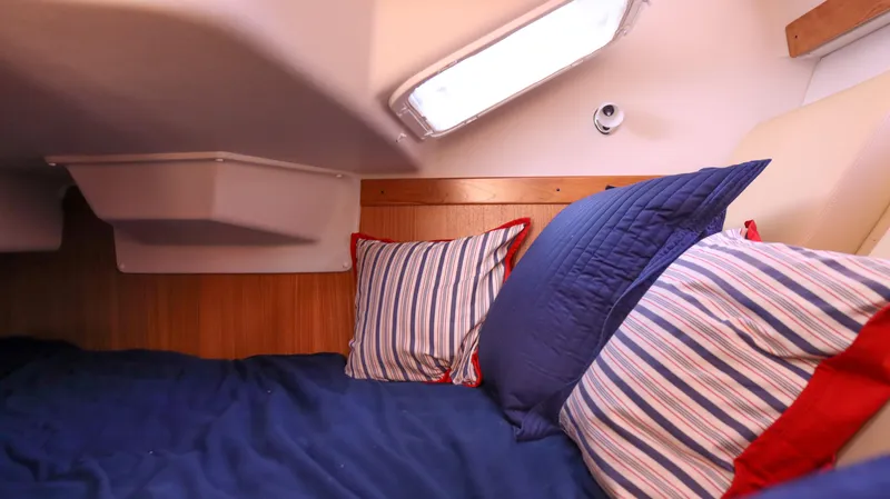Slide: The Image of Cozy cabin interior of 2010 Catalina 375 sailboat with striped pillows and blue bedding. - 9