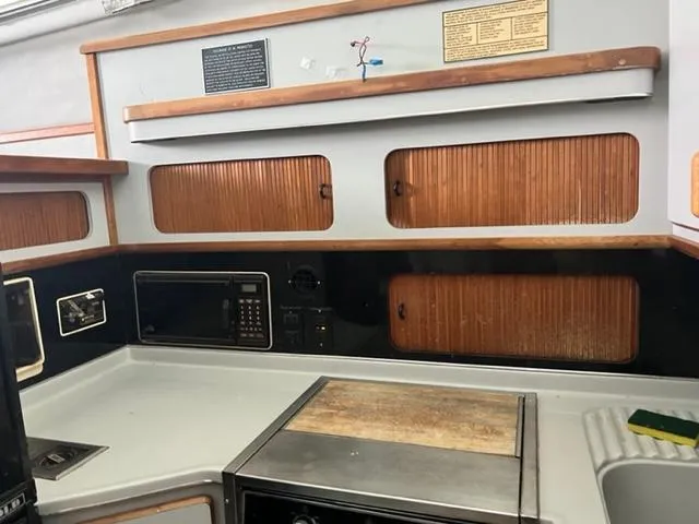 Slide: The Image of 1990 Sea Ray 380 Aft Cabin kitchen with wooden cabinets and modern appliances. - 10
