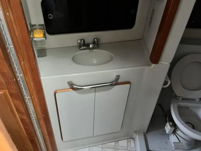 Slide: The Image of 1990 Sea Ray 380 Aft Cabin bathroom with sink and toilet. - 13