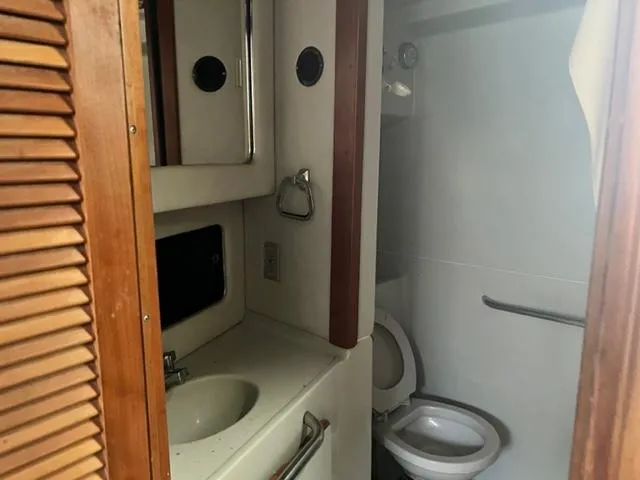 Slide: The Image of 1990 Sea Ray 380 Aft Cabin bathroom with sink, mirror, and toilet. - 14
