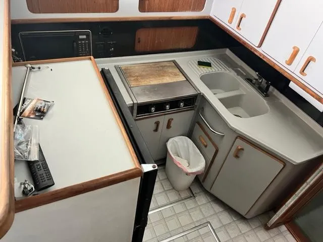 Slide: The Image of 1990 Sea Ray 380 Aft Cabin kitchen with sink, stove, and cabinets. - 16