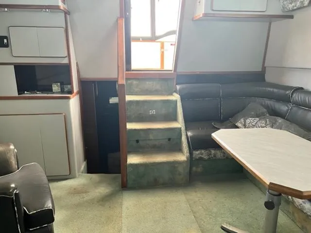 Slide: The Image of Interior of 1990 Sea Ray 380 Aft Cabin with stairs, seating, and table. - 8