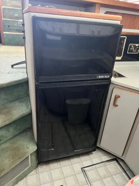 Slide: The Image of 1990 Sea Ray 380 Aft Cabin kitchen with black refrigerator - 9