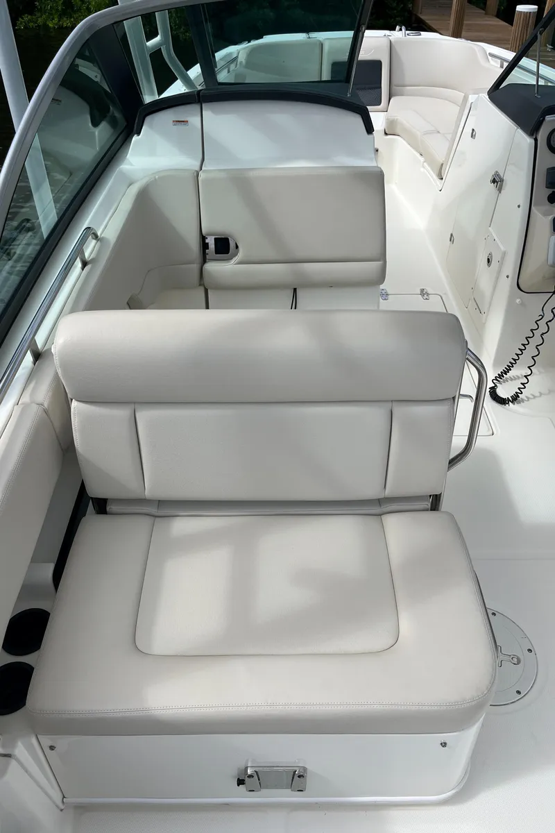 Slide: The Image of 2016 Boston Whaler 230 Vantage boat interior with white cushioned seating. - 14