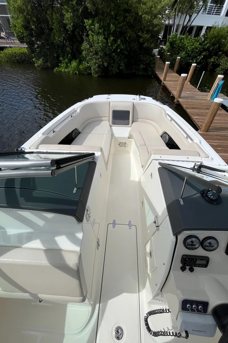 Slide: The Image of 2016 Boston Whaler 230 Vantage boat docked near lush greenery. - 17