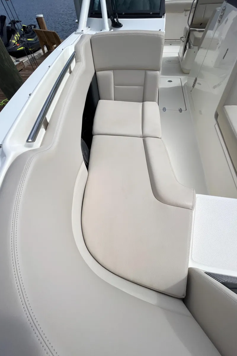 Slide: The Image of 2016 Boston Whaler 230 Vantage boat interior with cushioned seating. - 18