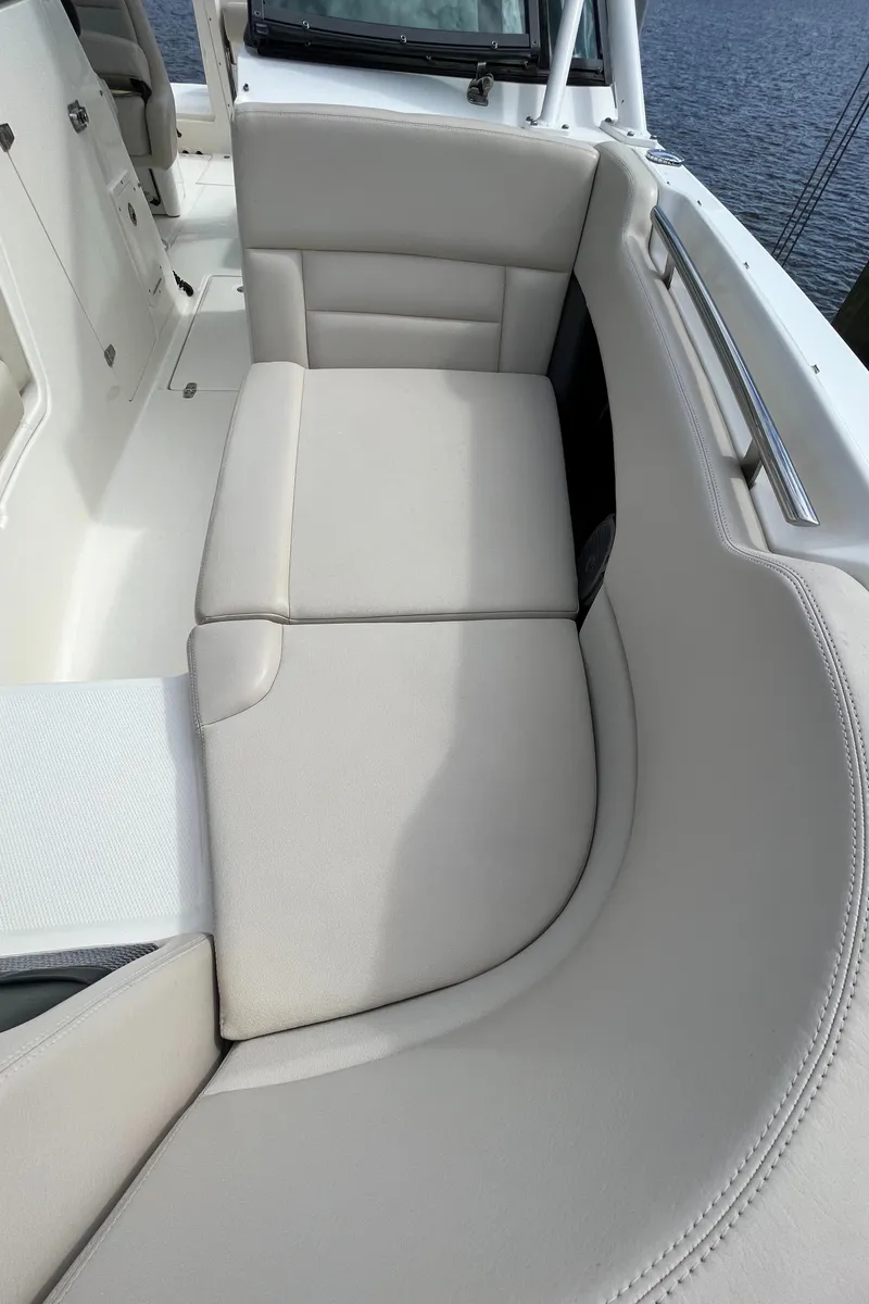 Slide: The Image of 2016 Boston Whaler 230 Vantage boat with beige cushioned seating. - 19