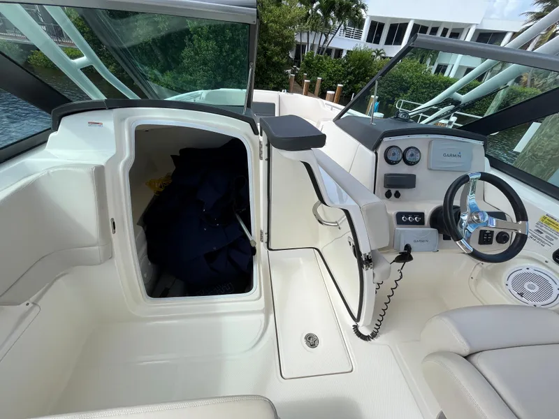 Slide: The Image of 2016 Boston Whaler 230 Vantage boat cockpit with open storage compartment and helm. - 21