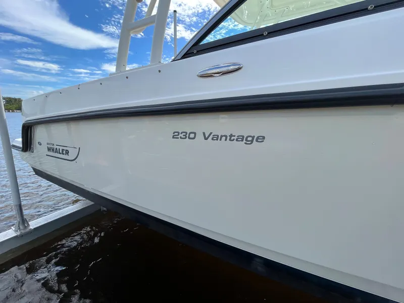 Slide: The Image of 2016 Boston Whaler 230 Vantage boat side view on water. - 25
