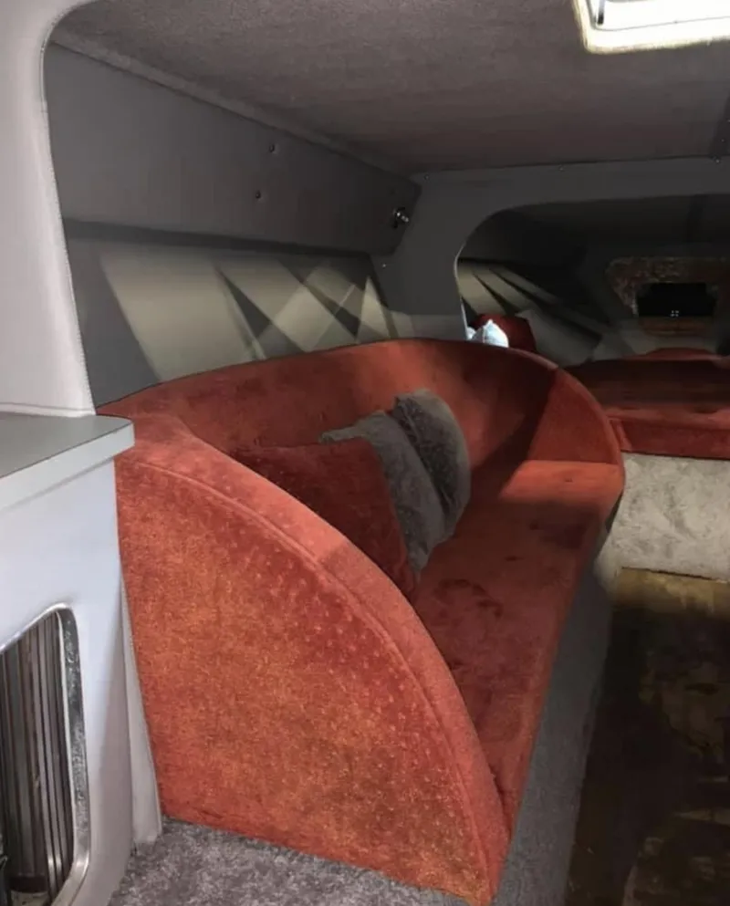 Slide: The Image of Interior of a 1989 Fountain 12m boat with red upholstered seating. - 12