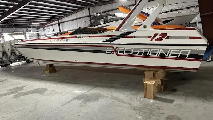 Slide: The Image of 1989 Fountain 12m Executioner speedboat in storage on wooden blocks. - 2