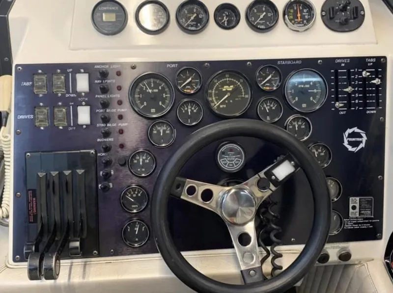 Slide: The Image of 1989 Fountain 12m boat dashboard with steering wheel and control gauges. - 4