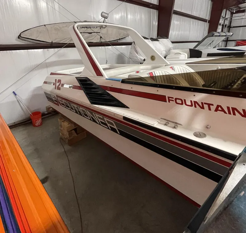 Slide: The Image of 1989 Fountain 12m speedboat in storage, white with red and black accents. - 7