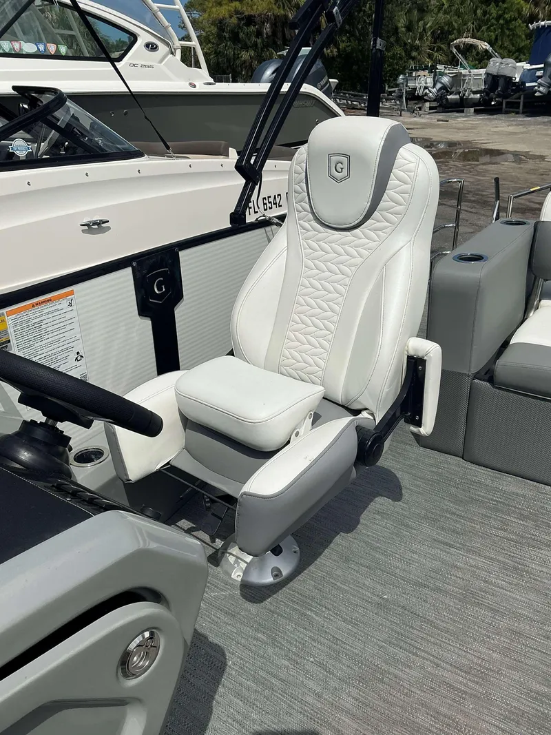 Slide: The Image of Captain's chair on a 2023 MONACO 235 DFL boat, featuring luxurious white upholstery. - 10
